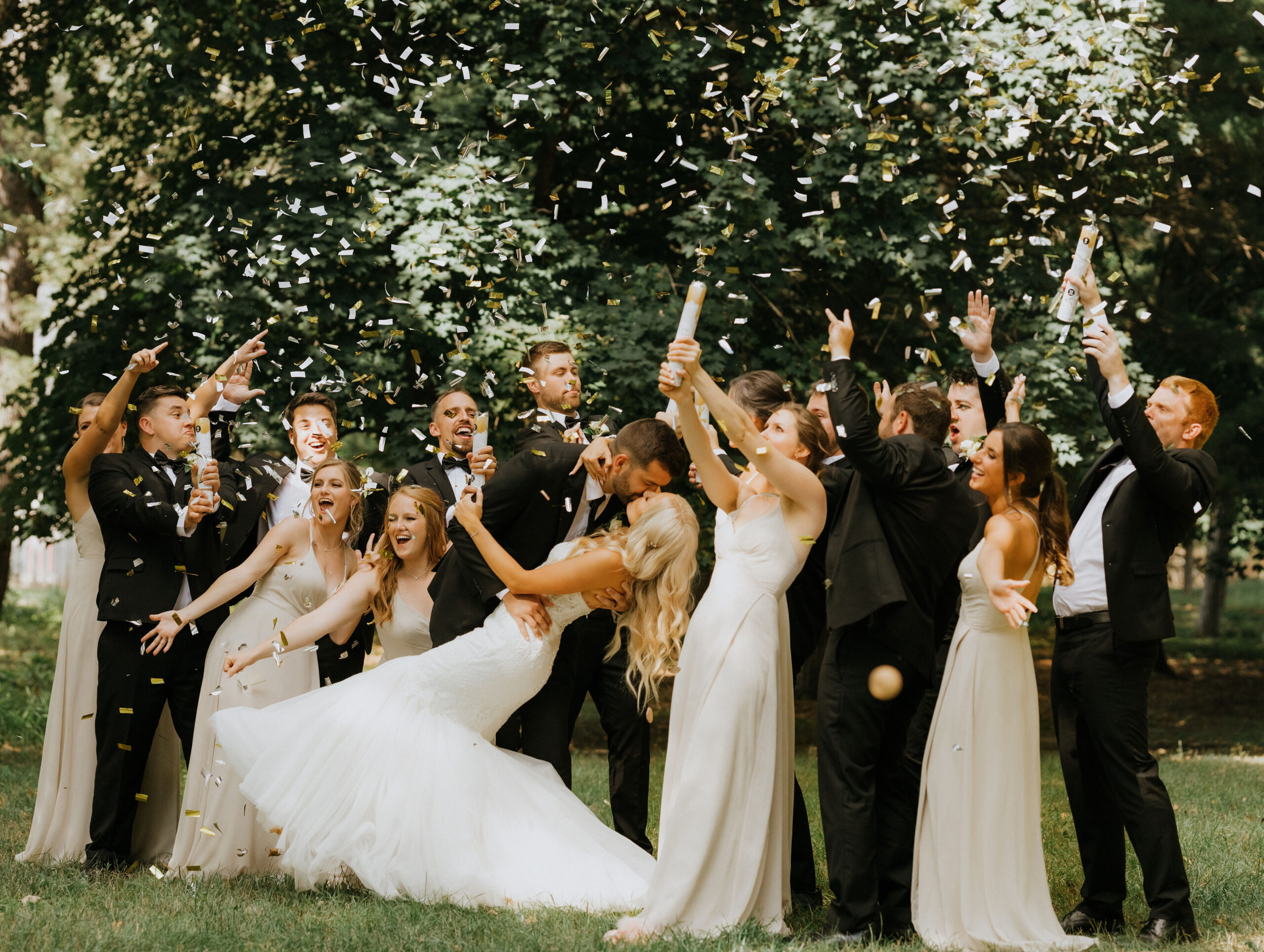 Wedding party celebrating with confetti at a park
